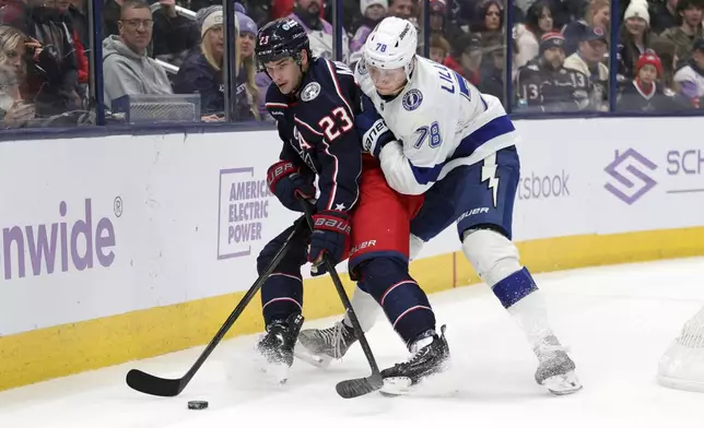 Columbus Blue Jackets defenseman Sean Monahan, left, works for the puck in front of Tampa Bay Lightning defenseman Emil Martinsen Lilleberg, right, during the second period of an NHL hockey game in Columbus, Ohio, Thursday, Nov. 21, 2024. (AP Photo/Paul Vernon)