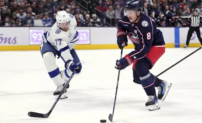 Columbus Blue Jackets defenseman Zach Werenski, right, controls the puck in front of Tampa Bay Lightning defenseman Victor Hedman, left, during the second period of an NHL hockey game in Columbus, Ohio, Thursday, Nov. 21, 2024. (AP Photo/Paul Vernon)