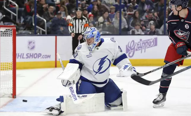 Columbus Blue Jackets forward Dmitri Voronkov, right, watches a goal by teammate Zach Werenski (not shown) get past Tampa Bay Lightning goalie Jonas Johansson, left, during the second period of an NHL hockey game in Columbus, Ohio, Thursday, Nov. 21, 2024. (AP Photo/Paul Vernon)