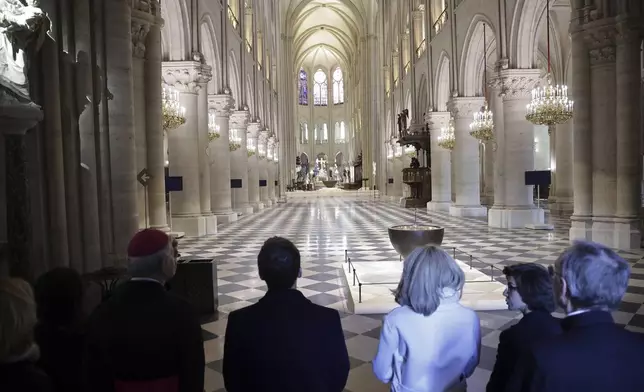 French President Emmanuel Macron, center left, and his wife Brigitte Macron, third right, visit the restored interiors of Notre-Dame Cathedral, Friday, Nov.29, 2024 in Paris. (Christophe Petit Tesson, Pool via AP)