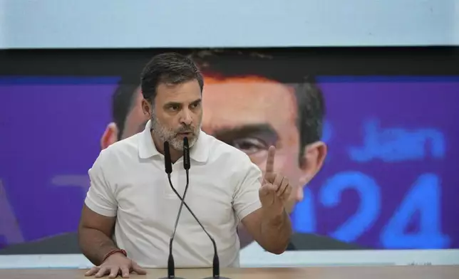 India's opposition Congress party leader Rahul Gandhi addresses the media on Indian businessman Gautam Adani, after Adani was indicted by U.S. prosecutors on charges he duped investors in a massive solar energy project in India, in New Delhi, India, Thursday, Nov. 21, 2024. Image behind shows Adani. (AP Photo/Manish Swarup)