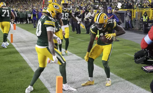 Green Bay Packers wide receiver Jayden Reed (11) celebrates after catching a 12-yard touchdown pass during the first half of an NFL football game against the Miami Dolphins Thursday, Nov. 28, 2024, in Green Bay, Wis. (AP Photo/Mike Roemer)