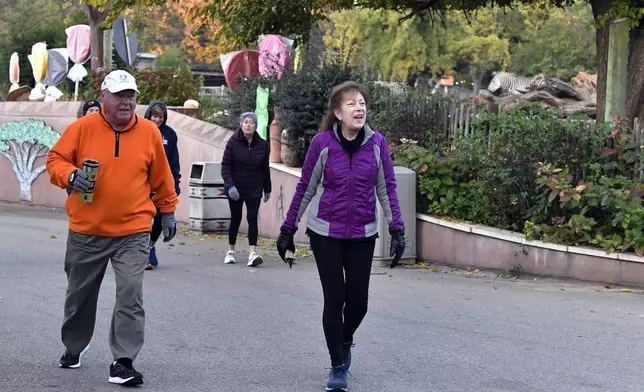 Members of the Get Healthy Walking Club walk the paths past the animal enclosures during the morning at the Louisville Zoo in Louisville, Ky., Friday, Oct. 18, 2024. (AP Photo/Timothy D. Easley)