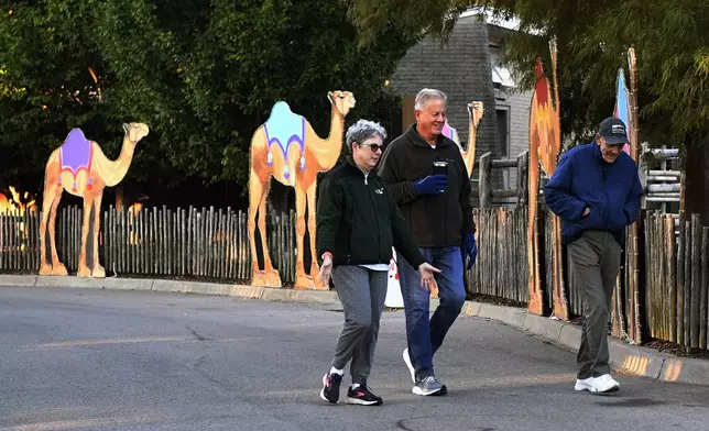 Members of the Get Healthy Walking Club walk the paths past the animal enclosures during the early morning at the Louisville Zoo in Louisville, Ky., Friday, Oct. 18, 2024. (AP Photo/Timothy D. Easley)