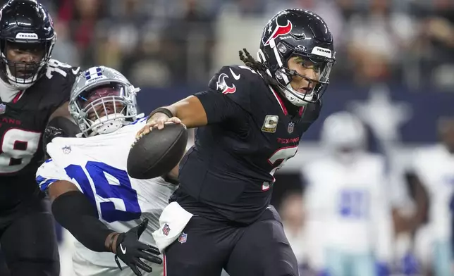 Houston Texans quarterback C.J. Stroud, right, gets help from offensive tackle Laremy Tunsil, left, to escape a tackle attempt by Dallas Cowboys quarterback Trey Lance during the second half of an NFL football game, Monday, Nov. 18, 2024, in Arlington, Texas. (AP Photo/Tony Gutierrez)