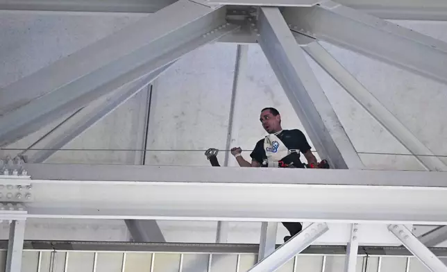 A employee labors on the catwalk of AT&amp;T Stadium prior to an NFL football game between the Dallas Cowboys and the Houston Texans, Monday, Nov. 18, 2024, in Arlington. (AP Photo/Jerome Miron)