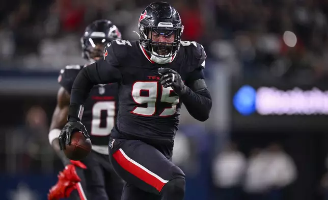 Houston Texans defensive end Derek Barnett runs with the ball while scoring on a fumble recovery during the second half of an NFL football game against the Dallas Cowboys, Monday, Nov. 18, 2024, in Arlington, Texas. (AP Photo/Jerome Miron)