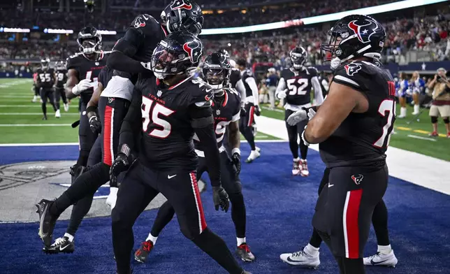 Houston Texans defensive end Derek Barnett (95) celebrates with teammates after scoring on a fumble recovery during the second half of an NFL football game against the Dallas Cowboys, Monday, Nov. 18, 2024, in Arlington, Texas. (AP Photo/Jerome Miron)