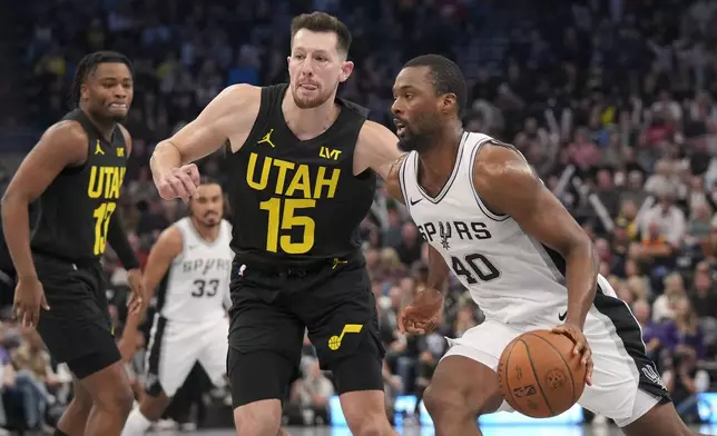 San Antonio Spurs forward Harrison Barnes (40) drives to the basket as Utah Jazz forward Drew Eubanks (15) and guard Isaiah Collier (13) defend during the second half of an NBA basketball game, on Tuesday, Nov. 26, 2024, in Salt Lake City. (AP Photo/Bethany Baker)