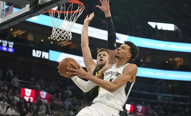 San Antonio Spurs center Victor Wembanyama, front, goes for a layup as Utah Jazz center Walker Kessler defends during the second half of an NBA basketball game, on Tuesday, Nov. 26, 2024, in Salt Lake City. (AP Photo/Bethany Baker)