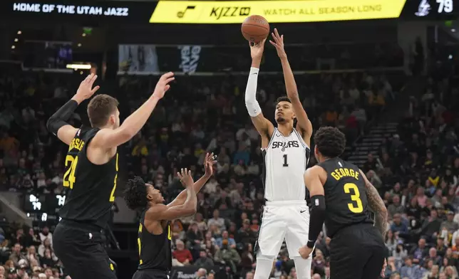 San Antonio Spurs center Victor Wembanyama (1) shoots as Utah Jazz guard Keyonte George (3), center Walker Kessler (24) and guard Collin Sexton (2) defend during the second half of an NBA basketball game, on Tuesday, Nov. 26, 2024, in Salt Lake City. (AP Photo/Bethany Baker)