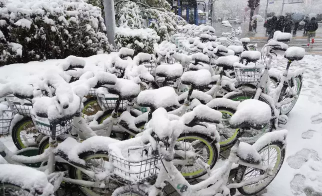 Snow-covered bicycles are parked near a subway station in Seoul, South Korea, Wednesday, Nov. 27, 2024. (AP Photo/Ahn Young-joon)