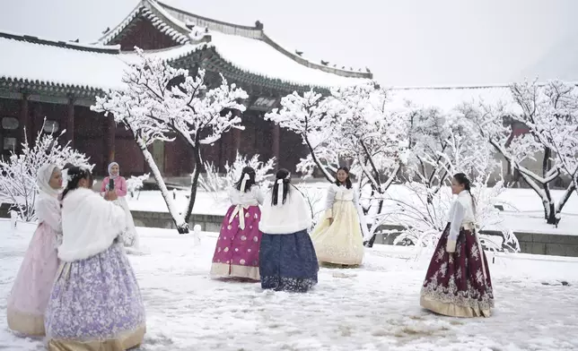 Visitors enjoy in snow at the Gyeongbok Palace, one of South Korea's well-known landmarks, in Seoul, South Korea, Wednesday, Nov. 27, 2024. (AP Photo/Lee Jin-man)