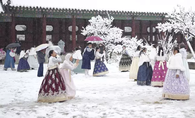 Visitors enjoy in snow at the Gyeongbok Palace, one of South Korea's well-known landmarks, in Seoul, South Korea, Wednesday, Nov. 27, 2024. (AP Photo/Lee Jin-man)