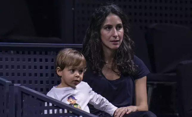 Rafael Nadal's wife, Xisca Perello, and their son, Rafael Nadal Jr watch the training session of Rafael Nadal at the Martin Carpena Sports Hall, in Malaga, southern Spain, on Saturday, Nov. 16, 2024. (AP Photo/Manu Fernandez)