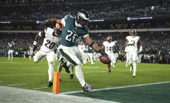 Philadelphia Eagles running back Saquon Barkley (26) scores during the second half of an NFL football game against the Washington Commanders Thursday, Nov. 14, 2024, in Philadelphia. (AP Photo/Matt Slocum)