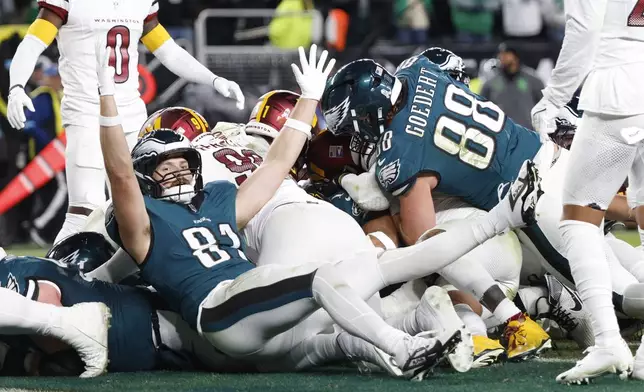 Philadelphia Eagles tight end Grant Calcaterra (81) celebrates a 1-yard touchdown by teammate Jalen Hurts during the second half of an NFL football game against the Washington Commanders Thursday, Nov. 14, 2024, in Philadelphia. (AP Photo/Laurence Kesterson)