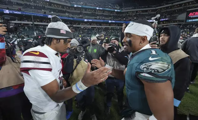 Philadelphia Eagles quarterback Jalen Hurts (1) and Washington Commanders quarterback Jayden Daniels shake hands following an NFL football game Thursday, Nov. 14, 2024, in Philadelphia. The Eagles won 26-18. (AP Photo/Chris Szagola)