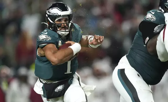 Philadelphia Eagles quarterback Jalen Hurts (1) runs with the ball during the first half of an NFL football game against the Washington Commanders Thursday, Nov. 14, 2024, in Philadelphia. (AP Photo/Matt Slocum)