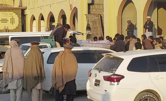 Relatives load the body of a victim, who was killed in a gunmen firing incident, into a vehicle at a hospital, in Parachinar, main town of Kurram district of Pakistan's northwestern Khyber Pakhtunkhwa province, Friday, Nov. 22, 2024. (AP Photo/Hussain Ali)