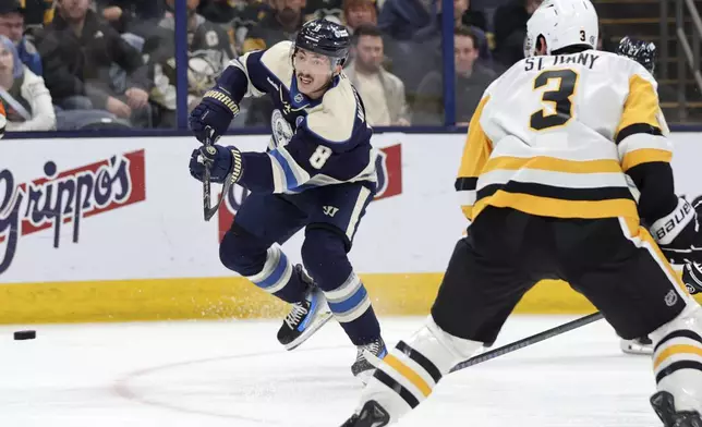 Columbus Blue Jackets defenseman Zach Werenski, left, shoots the puck in front of Pittsburgh Penguins defenseman Jack St. Ivany during the second period of an NHL hockey game in Columbus, Ohio, Friday, Nov. 15, 2024. (AP Photo/Paul Vernon)