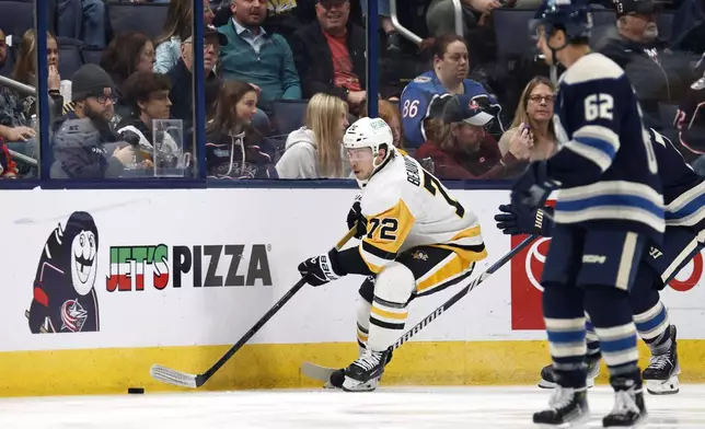 Pittsburgh Penguins forward Anthony Beauvillier, left, controls the puck in front of Columbus Blue Jackets forward Kevin Labanc during the second period of an NHL hockey game in Columbus, Ohio, Friday, Nov. 15, 2024. (AP Photo/Paul Vernon)