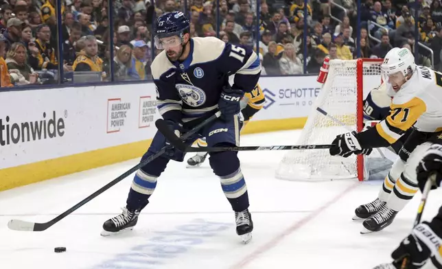 Columbus Blue Jackets defenseman Gavin Bayreuther, left, controls the puck in front of Pittsburgh Penguins forward Evgeni Malkin during the first period of an NHL hockey game in Columbus, Ohio, Friday, Nov. 15, 2024. (AP Photo/Paul Vernon)