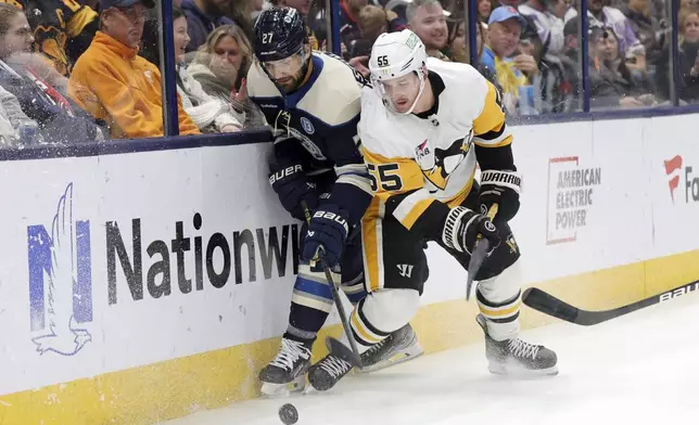 Columbus Blue Jackets defenseman Zachary Aston-Reese, left, works for the puck against Pittsburgh Penguins forward Noel Acciari during the second period of an NHL hockey game in Columbus, Ohio, Friday, Nov. 15, 2024. (AP Photo/Paul Vernon)