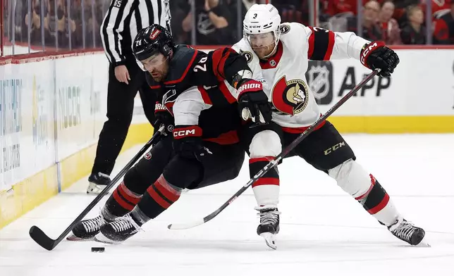 Carolina Hurricanes' William Carrier (28) protects the puck from Ottawa Senators' Nick Jensen (3) during the second period of an NHL hockey game in Raleigh, N.C., Saturday, Nov. 16, 2024. (AP Photo/Karl B DeBlaker)