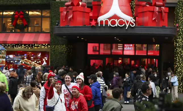 A group of shoppers take a selfie outside Macy's Herald Square, Friday, Nov. 29, 2024, in New York. (AP Photo/Heather Khalifa)