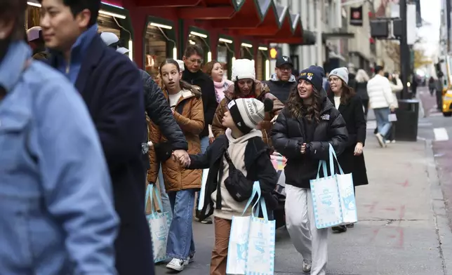 Shoppers walk along Fifth Avenue, Friday, Nov. 29, 2024, in New York. (AP Photo/Heather Khalifa)