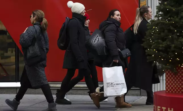 Shoppers walk along Fifth Avenue, Friday, Nov. 29, 2024, in New York. (AP Photo/Heather Khalifa)