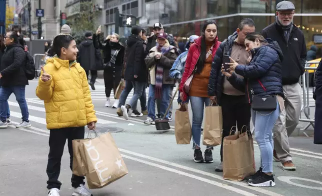 Shoppers take photos outside Macy's Herald Square, Friday, Nov. 29, 2024, in New York. (AP Photo/Heather Khalifa)