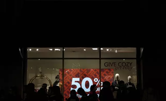 Early Black Friday shoppers are silhouetted as they wait in line to enter a store at Citadel Outlets in Commerce, Calif., Thursday, Nov. 28, 2024. (AP Photo/Jae C. Hong)