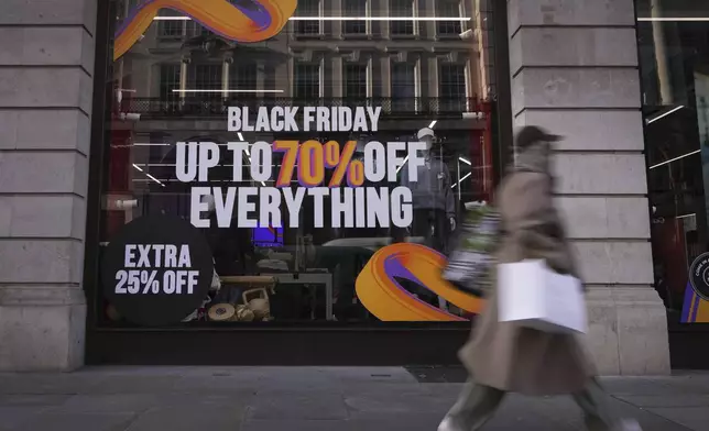 A shopper passes a store advertising a Black Friday Sale on Regent Street in London, Thursday, Nov. 28, 2024. (AP Photo/Kirsty Wigglesworth)