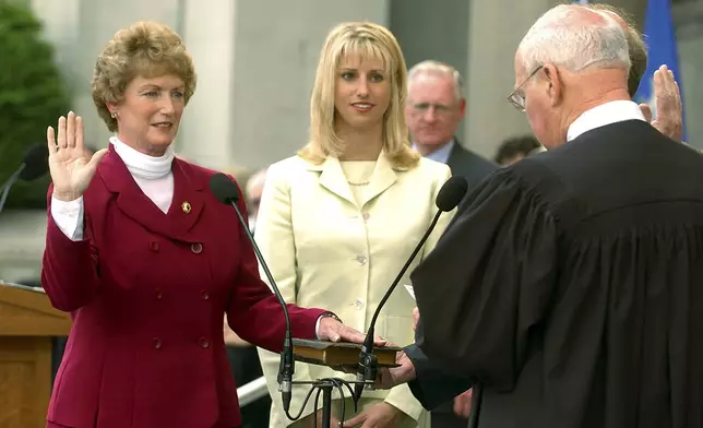 FILE - M. Jodi Rell is sworn in as Governor of Connecticut by state Supreme Court Chief Justice William J. Sullivan as her daughter, Meredith O'Connor, center, looks on in a ceremony on the steps of the state Capitol in Hartford, Conn., July 1, 2004. (AP Photo/Bob Child/Pool, File)