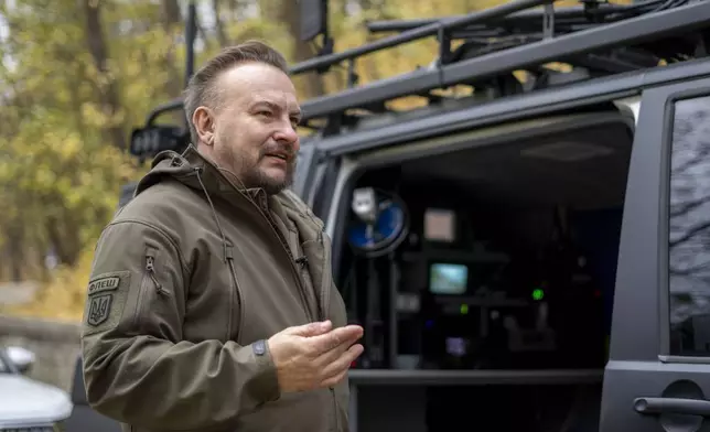 Serhii Beskrestnov, more widely known as Flash, a Ukrainian electronics expert, who hunts drones for the military, stands near his kitted-out black van in Kyiv, Ukraine, Monday, Nov. 4, 2024. (AP Photo/Hanna Arhirova)