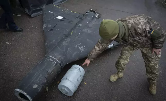 A Ukrainian officer shows a thermobaric charge of a downed Shahed drone launched by Russia in a research laboratory in an undisclosed location in Ukraine Thursday, Nov. 14, 2024. (AP Photo/Efrem Lukatsky)