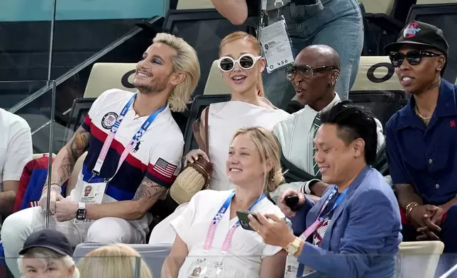 FILE - Frankie Grande, from left, Ariana Grande, Cynthia Erivo, and Lena Waithe, attend the women's artistic gymnastics qualification round at the 2024 Summer Olympics, Sunday, July 28, 2024, in Paris, France. In “Wicked,” Elphaba and Glinda travel from Shiz University to the Emerald City on a glistening green train to meet the wizard. In real life, Cynthia Erivo and Ariana Grande have traveled much farther and wider and longer and on airplanes to promote their hotly anticipated film. (AP Photo/Abbie Parr, File)