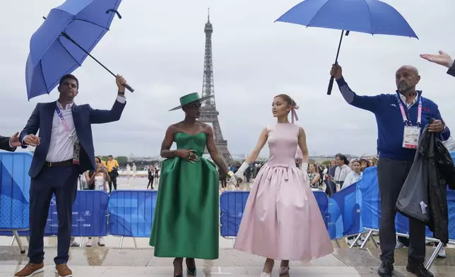 FILE - Cynthia Erivo, left, and Ariana Grande arrive in Paris, France, before the opening ceremony of the 2024 Summer Olympics, Friday, July 26, 2024. In "Wicked," Elphaba and Glinda travel from Shiz University to the Emerald City on a glistening green train to meet the wizard. In real life, Cynthia Erivo and Ariana Grande have traveled much farther and wider and longer and on airplanes to promote their hotly anticipated film. (AP Photo/Natacha Pisarenko, File)