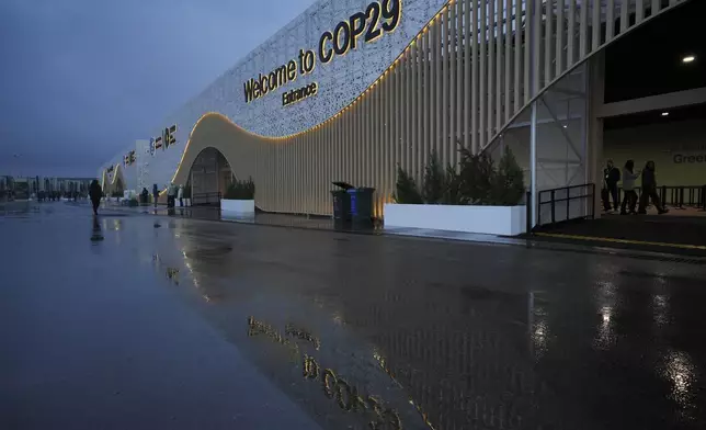 Attendees arrive for the day at the COP29 U.N. Climate Summit, Thursday, Nov. 14, 2024, in Baku, Azerbaijan. (AP Photo/Peter Dejong)