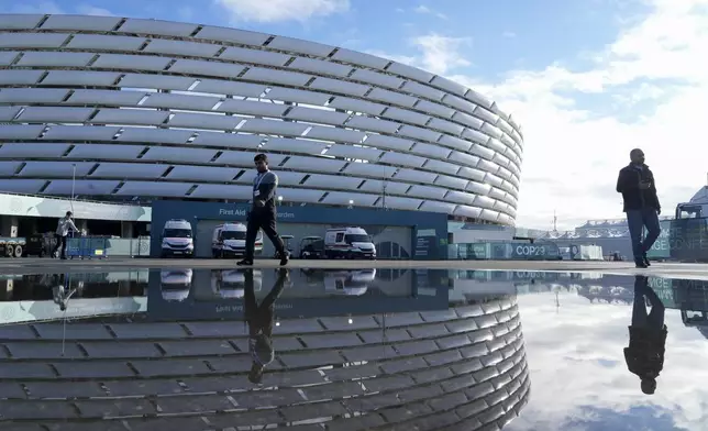 People walk outside the Baku Olympic Stadium at the COP29 U.N. Climate Summit, Thursday, Nov. 14, 2024, in Baku, Azerbaijan. (AP Photo/Rafiq Maqbool)