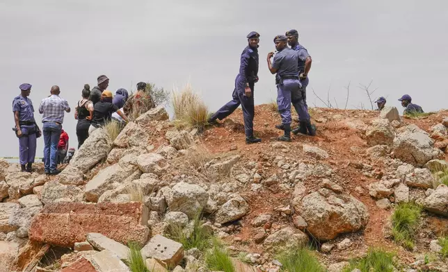 Police officers and volunteer rescuers stand by the opening of a reformed gold mineshaft where illegal miners are trapped in Stilfontein, South Africa, Friday, Nov. 15, 2024. (AP Photo/Denis Farrell)