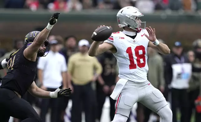 Ohio State quarterback Will Howard passes under pressure from Northwestern defensive lineman Aidan Hubbard during the first half of an NCAA college football game at Wrigley Field on Saturday, Nov. 16, 2024, in Chicago. (AP Photo/Charles Rex Arbogast)