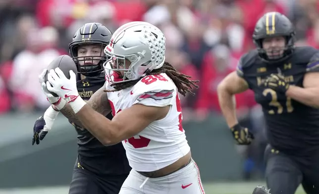 Ohio State tight end Gee Scott Jr. catches a deep pass from quarterback Will Howard as Northwestern linebacker Greyson Metz defends during the first half of an NCAA college football game at Wrigley Field on Saturday, Nov. 16, 2024, in Chicago. (AP Photo/Charles Rex Arbogast)