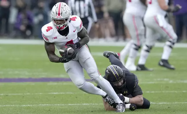 Ohio State wide receiver Jeremiah Smith catches a pass as Northwestern linebacker Greyson Metz defends during the first half of an NCAA college football game at Wrigley Field on Saturday, Nov. 16, 2024, in Chicago. (AP Photo/Charles Rex Arbogast)