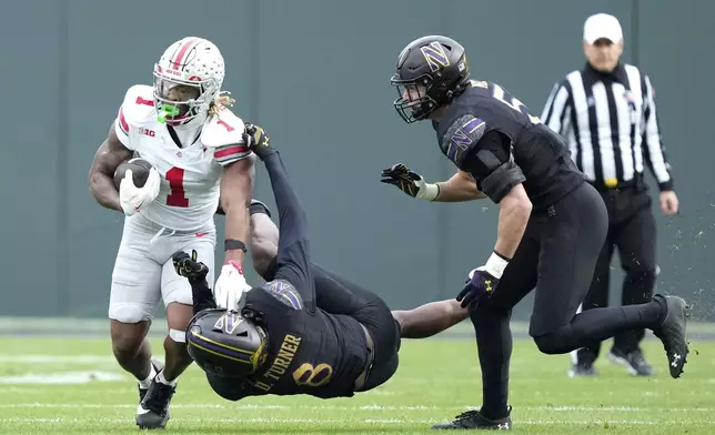 Ohio State running back Quinshon Judkins carries the ball as Northwestern defensive back Devin Turner (8) and linebacker Greyson Metz defend during the first half of an NCAA college football game at Wrigley Field on Saturday, Nov. 16, 2024, in Chicago. (AP Photo/Charles Rex Arbogast)