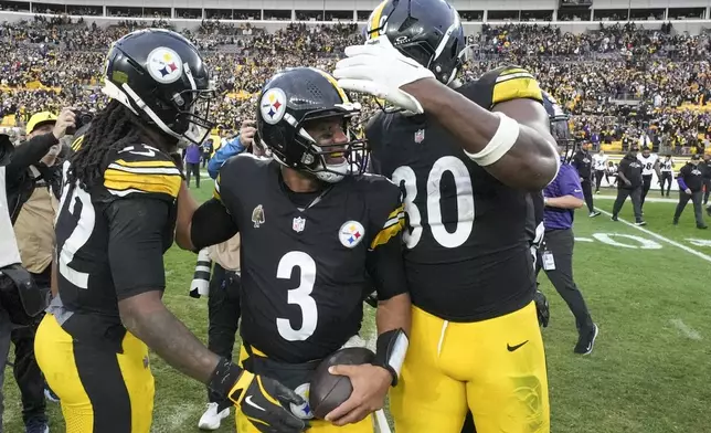 Pittsburgh Steelers quarterback Russell Wilson (3) reacts with teammates Najee Harris, left, and Darnell Washington at the end of an NFL football game against the Baltimore Ravens, Sunday, Nov. 17, 2024, in Pittsburgh. The Steelers won 18-16. (AP Photo/Gene J. Puskar)