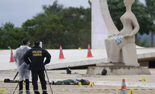 Federal police officers inspect a body outside the Supreme Court following an explosion the previous night, in Brasilia, Brazil, Thursday, Nov. 14, 2024. (AP Photo/Eraldo Peres)