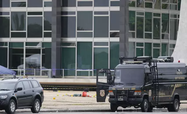 A body lies on the ground outside the Supreme Court following an explosion the previous night, in Brasilia, Brazil, Thursday, Nov. 14, 2024. (AP Photo/Eraldo Peres)